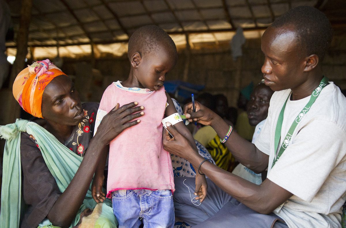 Copy of A GOAL nurse screening a child for malnutrition using a MUAC at Dingthoma IDP camp in South Sudan, 2017